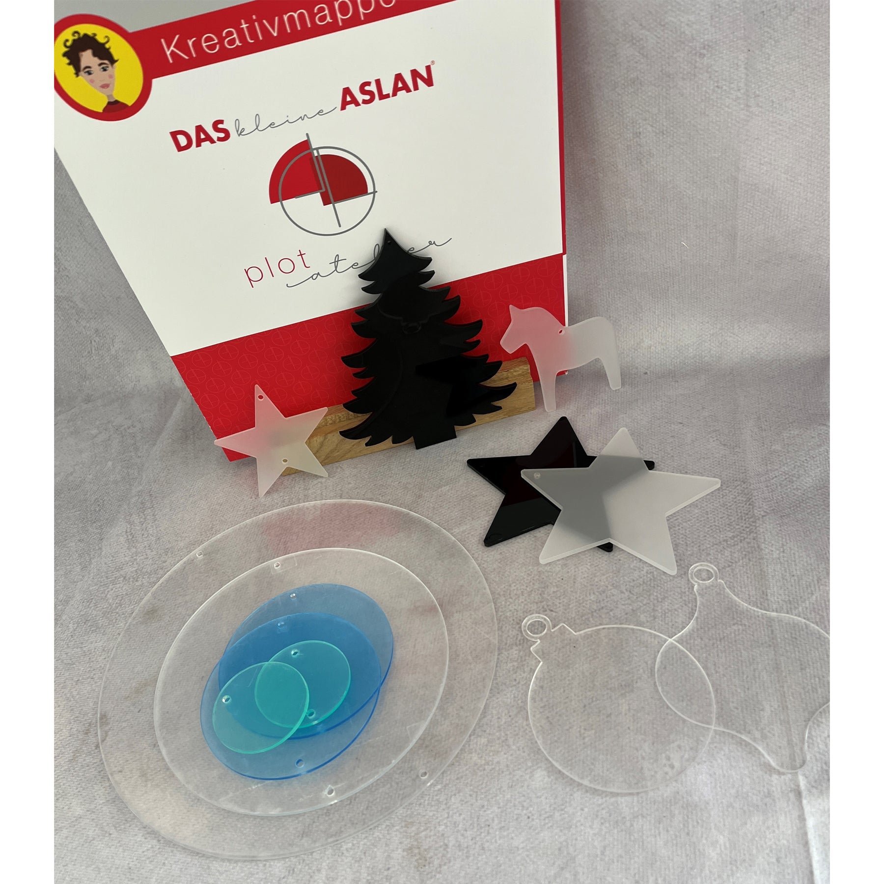 Crealive Acryl Set zum ASLAN PlotAtelier 21
Das Acryl Set passt perfekt zum kleinen ASLAN PlotAtelier 21 mit dem Thema: It´s beginning to look a lot like Christmas!
Die Kreativmappe 21 ist nicht im Preis inbegriffen und kannst du separat dazu bestellen.
Das Acryl Set besteht aus 13 Teilen:
• Das Set besteht aus:
• 1 x Anhänger schwarzer Tannenbaum
• 1 x Anhänger schwarzer Stern
• 1 x Anhänger satinierter Stern
• 1 x Anhänger satiniertes Dala Pferd
• 1 x klarer Anhänger Kugelrund