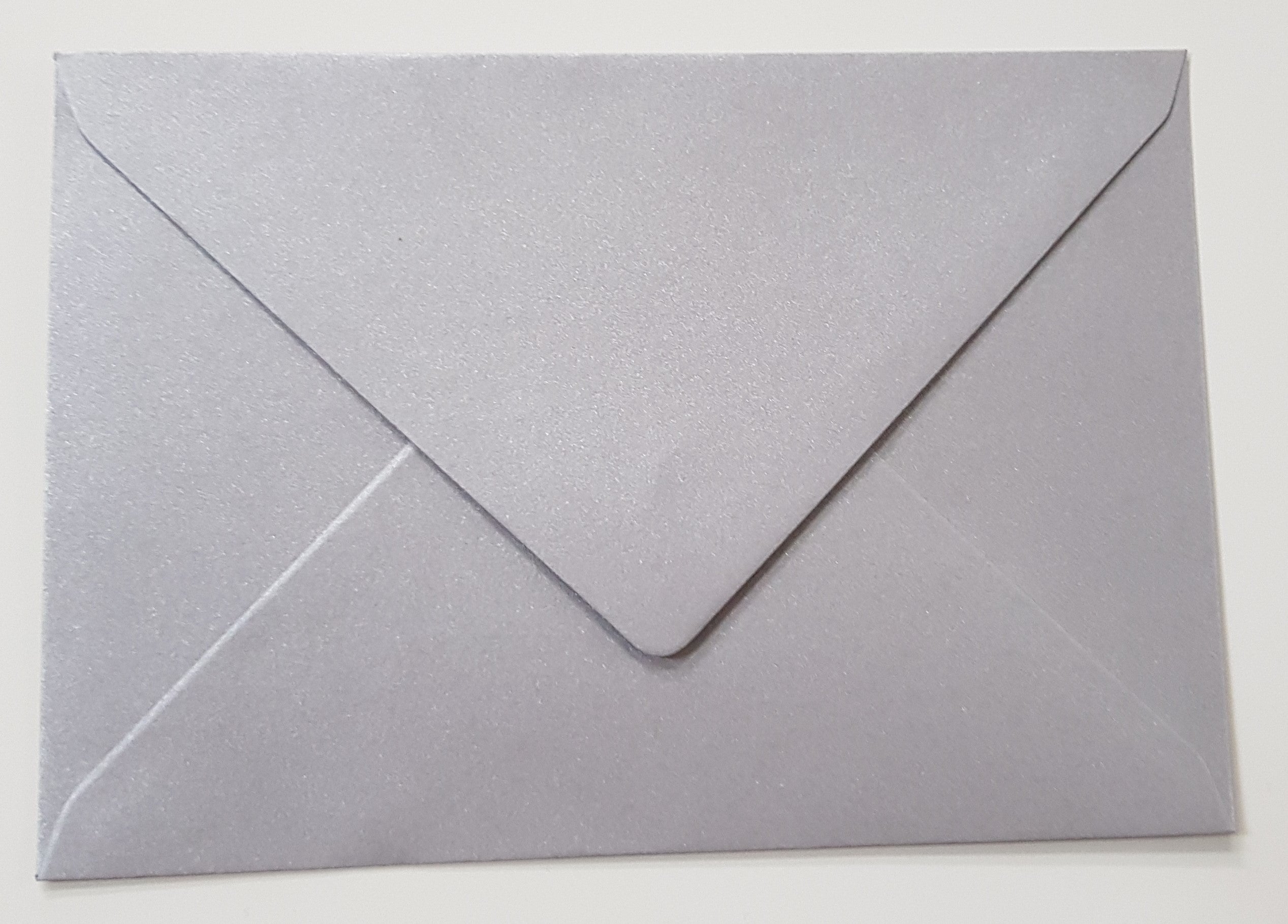 Kuvert / Briefumschlag 120 g/m2 - DIN B6 - Metallic silber Spezifikationen: Format: DIN B6 Grösse: 125 x 176 mm 120 g/m2 ohne Fenster Nassklebung oder Lasche zum Einstecken beidseitig farbig (voll durchgefärbt) bedruckbar mit Ink- und Laserdrucker beschreibbar glatte, in Metallic schimmernde Oberfläche