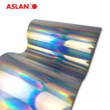 Crealive ASLAN Holographic SE 72 - Holographische Folie mit Regenbogeneffekt  Mit der silbernen Selbstklebefolie ASLAN Holographic SE 72 schillern deine Designs in allen Farben des Regenbogens UND das sogar auf beiden Seiten und ohne sichtbaren Übergang des Farbverlaufs. Perfekt also für die Anwendung auf Glas- und Fensterflächen.